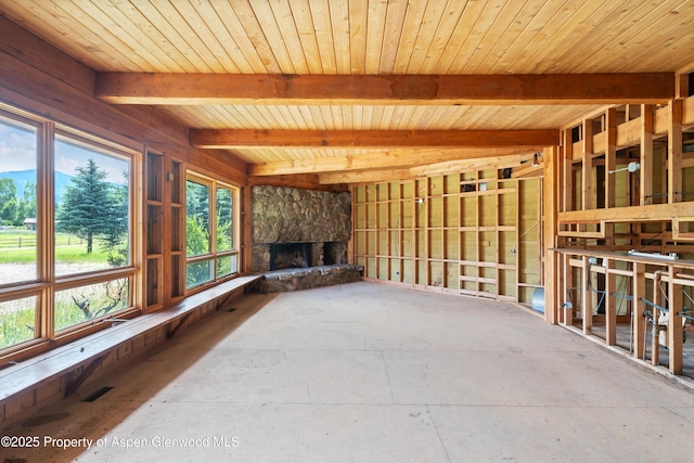 176 Letey Ln, Woody Creek, CO 81656 - unfurnished living room featuring healthy amount of natural light, a fireplace, and a wooden ceiling with exposed beams