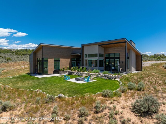 back of property featuring a patio and a lawn