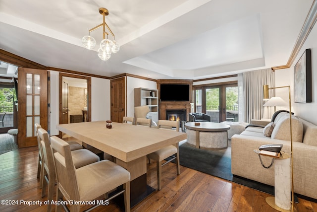 dining room with dark hardwood / wood-style flooring, french doors, and a tray ceiling