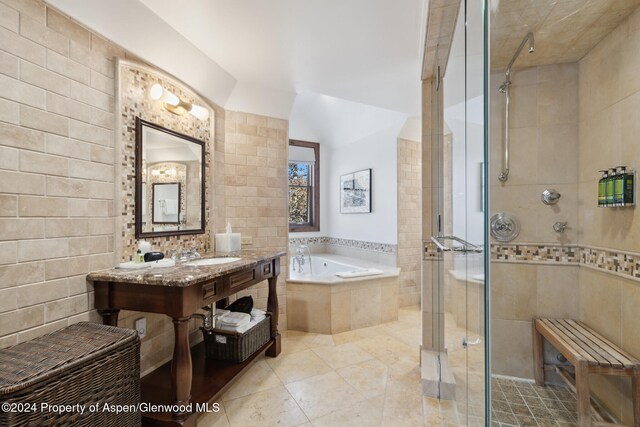 bathroom with tile patterned flooring, sink, tile walls, and independent shower and bath