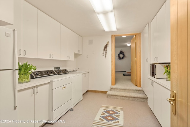 kitchen with white appliances, white cabinets, sink, washer and dryer, and baseboard heating