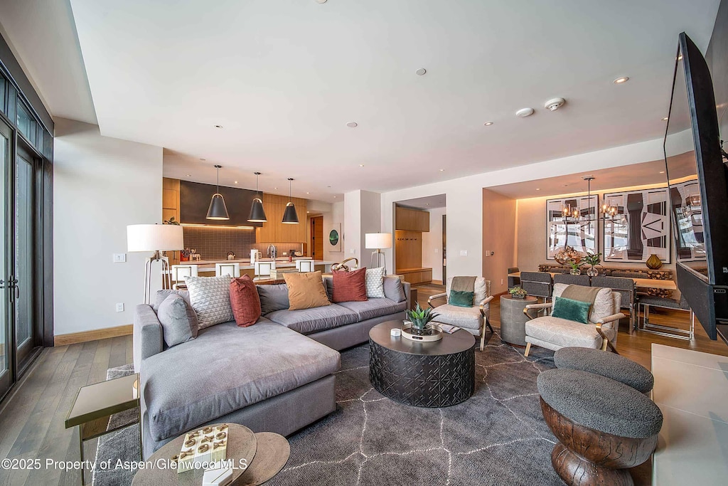 living room with hardwood / wood-style floors and a notable chandelier