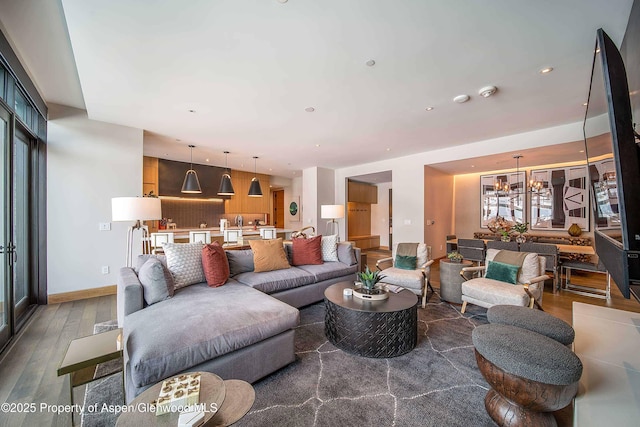 living room with hardwood / wood-style floors and a notable chandelier