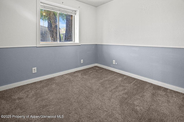 648 Colorado St, Craig, CO 81625 - unfurnished room with dark carpet, baseboards, and a textured wall