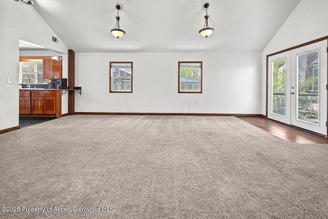 648 Colorado St, Craig, CO 81625 - unfurnished living room featuring lofted ceiling, dark colored carpet, healthy amount of natural light, baseboards, and french doors