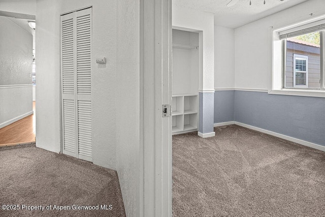 648 Colorado St, Craig, CO 81625 - hallway featuring carpet floors, a textured wall, and baseboards