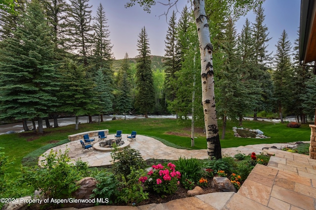 surrounding community with a lawn, a patio area, and an outdoor fire pit