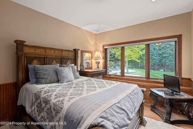 bedroom featuring wood walls and light hardwood / wood-style flooring