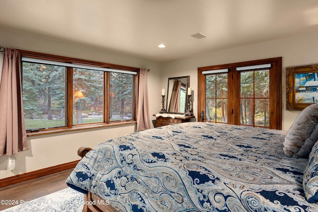 bedroom featuring light hardwood / wood-style flooring and multiple windows