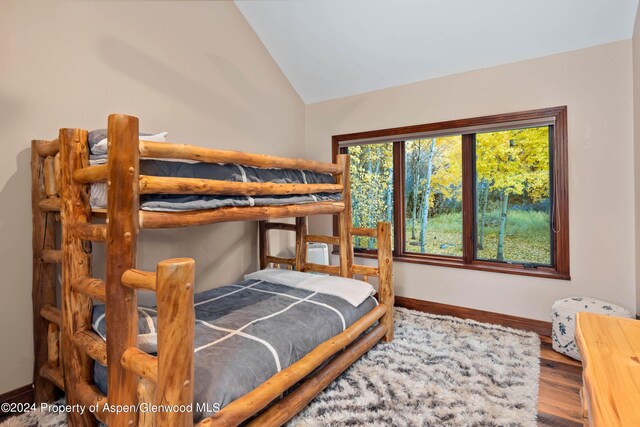 bedroom with wood-type flooring and lofted ceiling