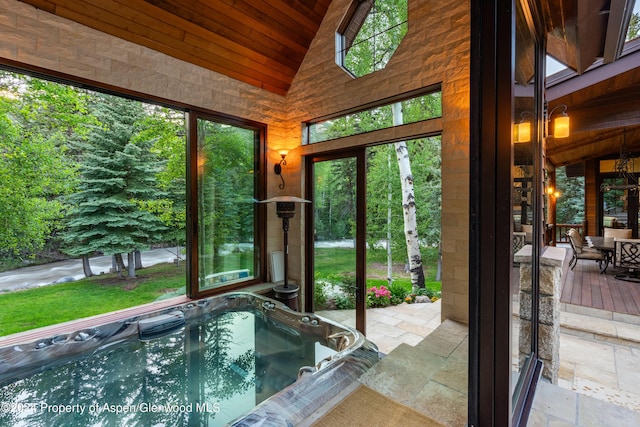 doorway to outside featuring high vaulted ceiling and wood ceiling