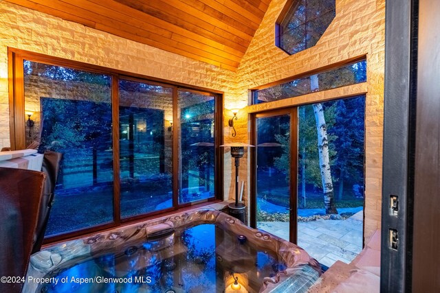 doorway to outside with lofted ceiling and wooden ceiling