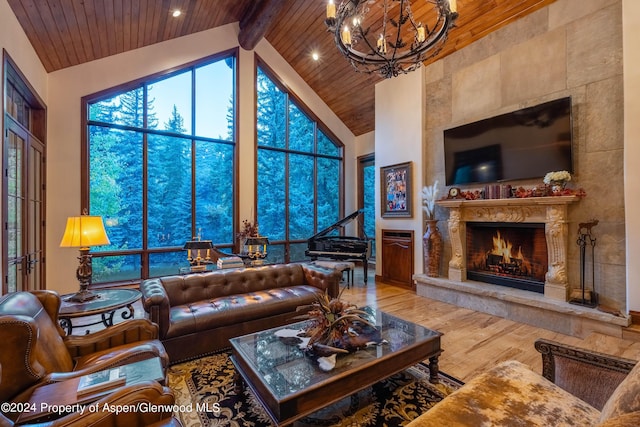 living room with a wealth of natural light, wood-type flooring, high vaulted ceiling, a premium fireplace, and beamed ceiling