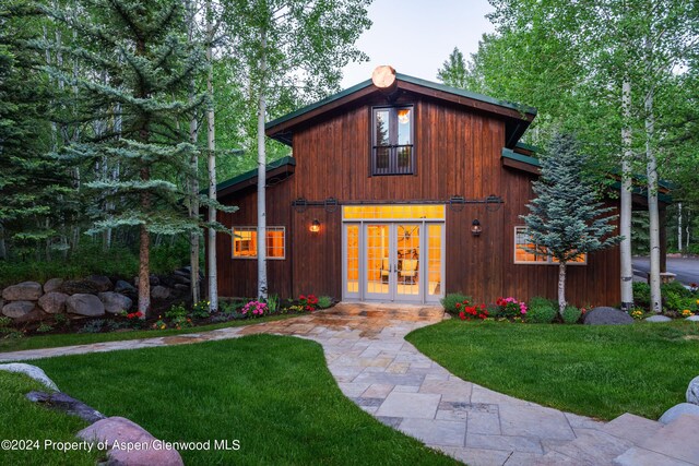 view of front of house featuring a front yard and french doors