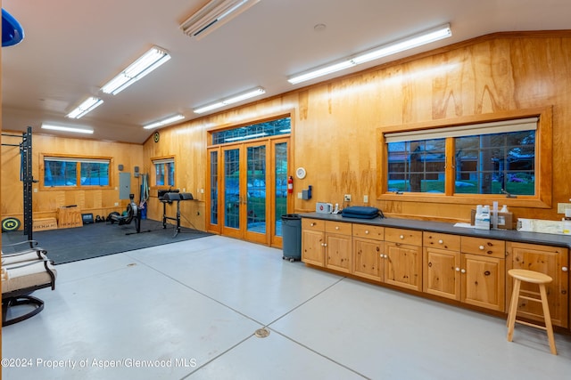 interior space with french doors and wood walls