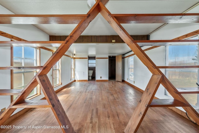 unfurnished living room featuring hardwood / wood-style floors and baseboards