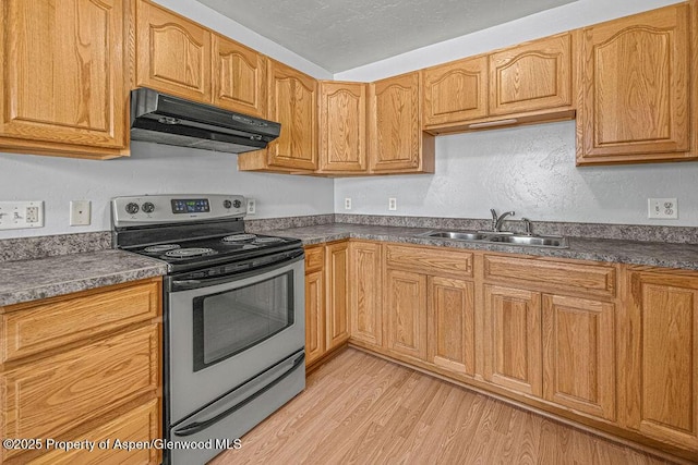 627 Lake St, Rangely, CO 81648 - kitchen featuring stainless steel electric stove, under cabinet range hood, dark countertops, and light wood-type flooring
