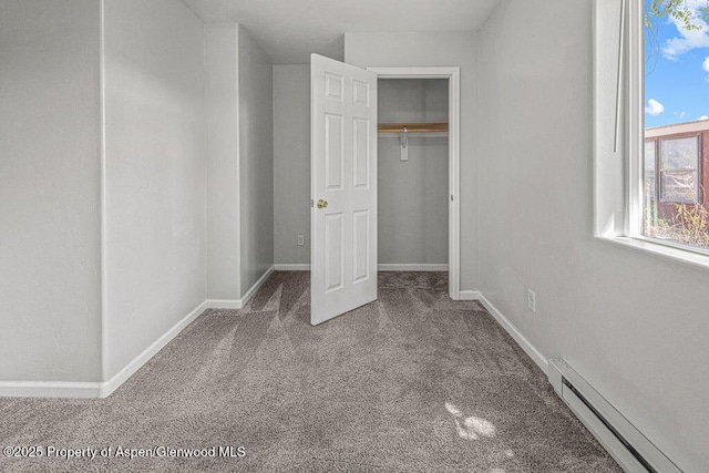 627 Lake St, Rangely, CO 81648 - unfurnished bedroom with carpet, a baseboard heating unit, and a closet
