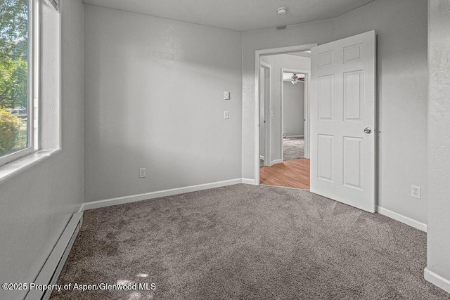 627 Lake St, Rangely, CO 81648 - carpeted spare room with baseboards and a baseboard heating unit