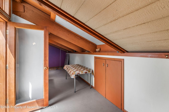 bonus room featuring lofted ceiling and concrete floors