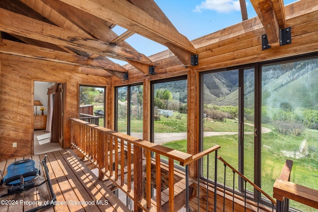 unfurnished sunroom with vaulted ceiling with beams