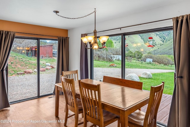 dining space featuring light hardwood / wood-style floors and an inviting chandelier