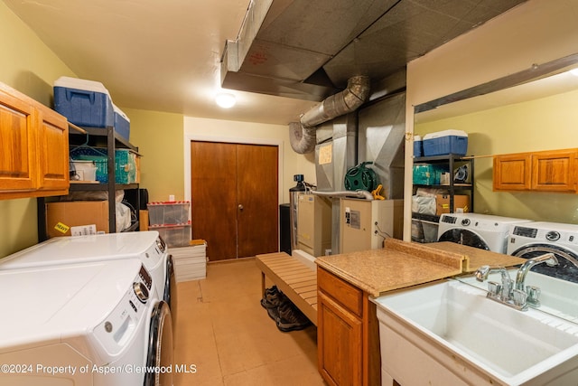 laundry room with washer and clothes dryer, cabinets, and sink