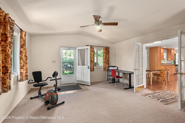 exercise room featuring ceiling fan, vaulted ceiling, light carpet, and french doors