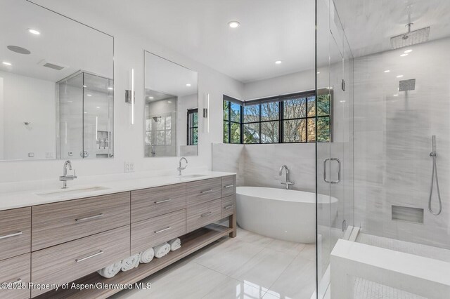 bathroom with tile patterned floors, vanity, and plus walk in shower