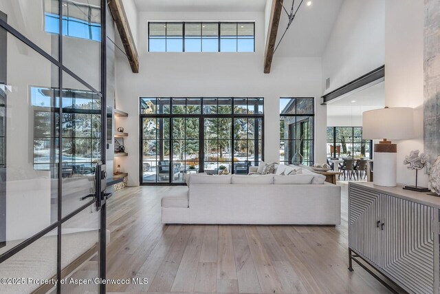 unfurnished living room featuring light hardwood / wood-style floors and a towering ceiling