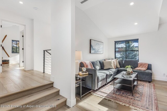 living room featuring light wood-type flooring and vaulted ceiling