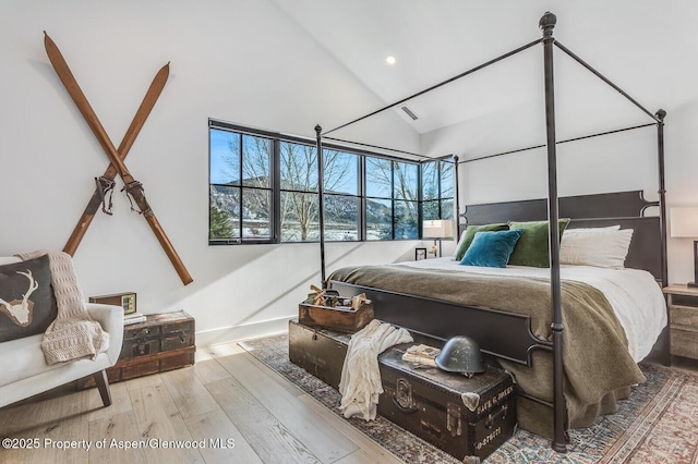 bedroom featuring light wood-type flooring and lofted ceiling