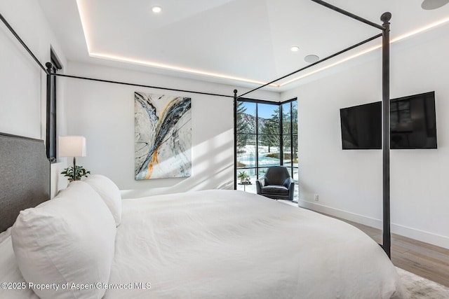 bedroom featuring hardwood / wood-style floors and a raised ceiling