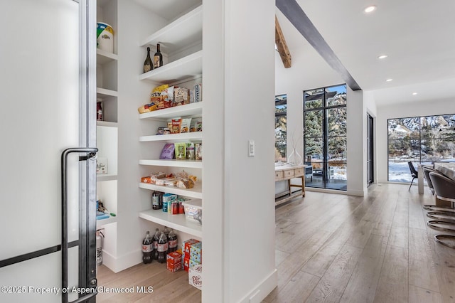 interior space with built in shelves and light hardwood / wood-style flooring