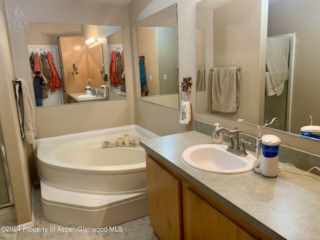 bathroom with tile patterned flooring, vanity, and a bathtub