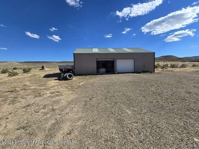 view of outdoor structure featuring a mountain view and a garage