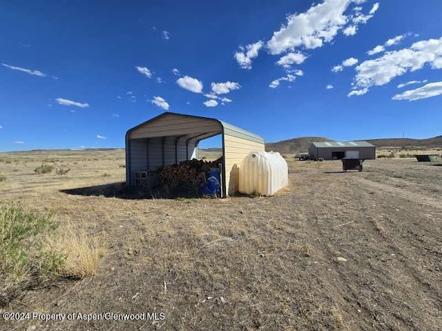 view of outbuilding with a rural view and a carport