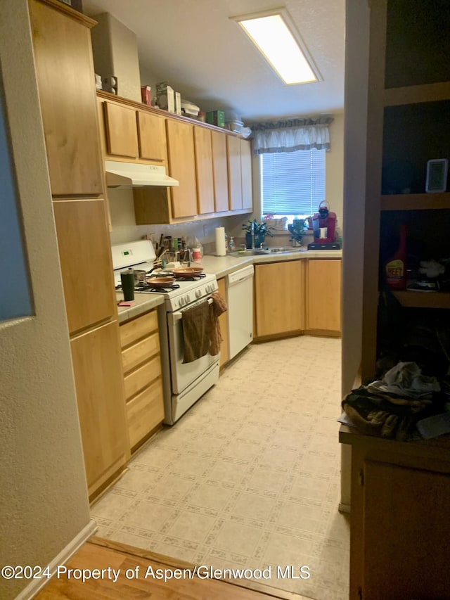 kitchen featuring light brown cabinets, white appliances, and sink