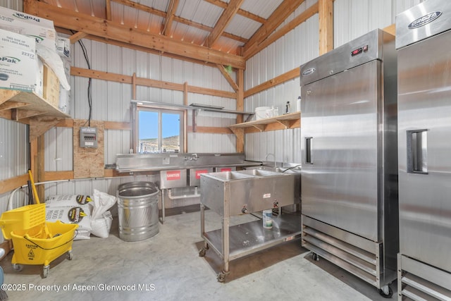1210 County Road 103, Craig, CO 81625 - kitchen with high quality fridge, concrete flooring, lofted ceiling, stainless steel counters, and metal wall