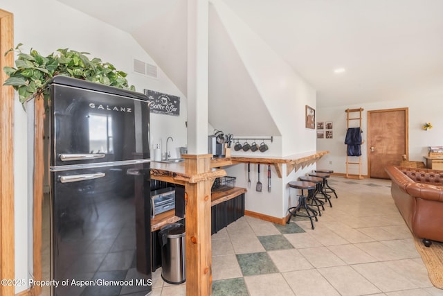 1210 County Road 103, Craig, CO 81625 - kitchen with freestanding refrigerator, a sink, light tile patterned floors, lofted ceiling, and baseboards