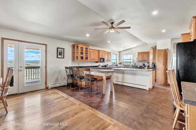 1210 County Road 103, Craig, CO 81625 - kitchen with a baseboard heating unit, a peninsula, glass insert cabinets, a breakfast bar, and vaulted ceiling