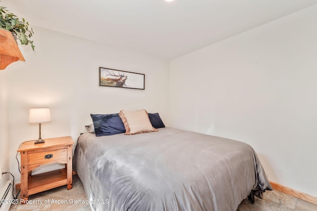 1210 County Road 103, Craig, CO 81625 - bedroom with baseboards, stone finish flooring, and a baseboard radiator