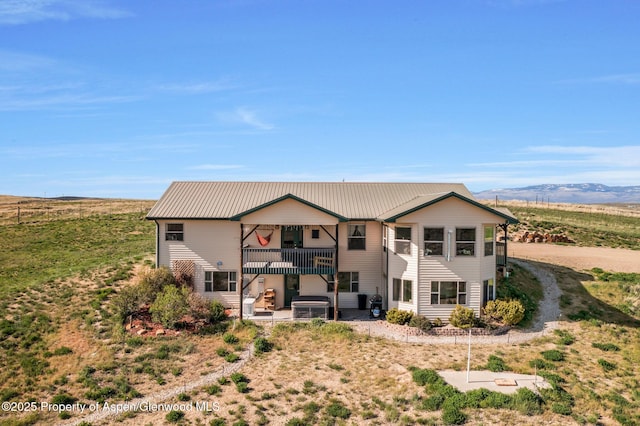 1210 County Road 103, Craig, CO 81625 - rear view of house with a patio, a balcony, metal roof, and a mountain view