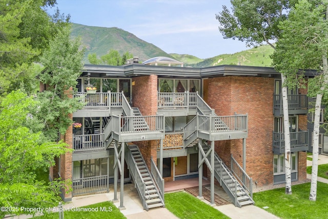 124 W Hyman Ave Unit 3B, Aspen, CO 81611 - view of front of property with stairway, brick siding, a mountain view, and a chimney