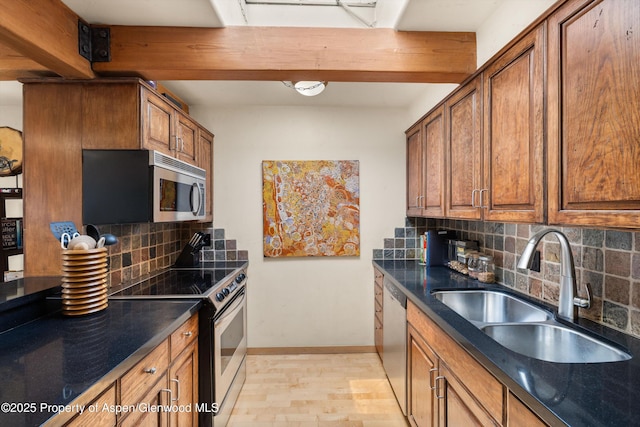 124 W Hyman Ave Unit 3B, Aspen, CO 81611 - kitchen featuring appliances with stainless steel finishes, dark countertops, brown cabinets, tasteful backsplash, and beam ceiling