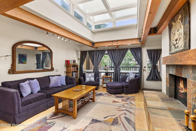 124 W Hyman Ave Unit 3B, Aspen, CO 81611 - living area featuring a tiled fireplace, beam ceiling, a high ceiling, and wood finished floors
