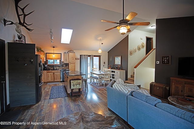 212 Safflower Ct, New Castle, CO 81647 - living room featuring dark wood finished floors, stairway, lofted ceiling, ceiling fan, and a skylight