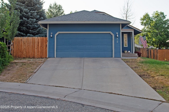 212 Safflower Ct, New Castle, CO 81647 - view of front facade with driveway, a garage, and roof with shingles