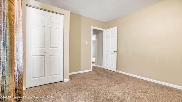 unfurnished bedroom featuring carpet and a closet