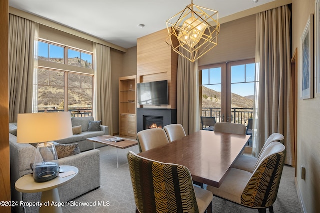 dining room featuring a large fireplace and a notable chandelier